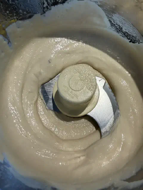 Smooth, pale, creamy tahini sauce in the food processor bowl